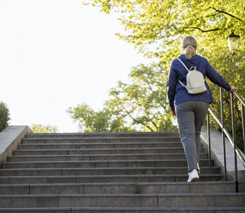 Magnesium Wirkung im Alltag: Frau läuft morgens eine sonnige Treppe im Park hinauf